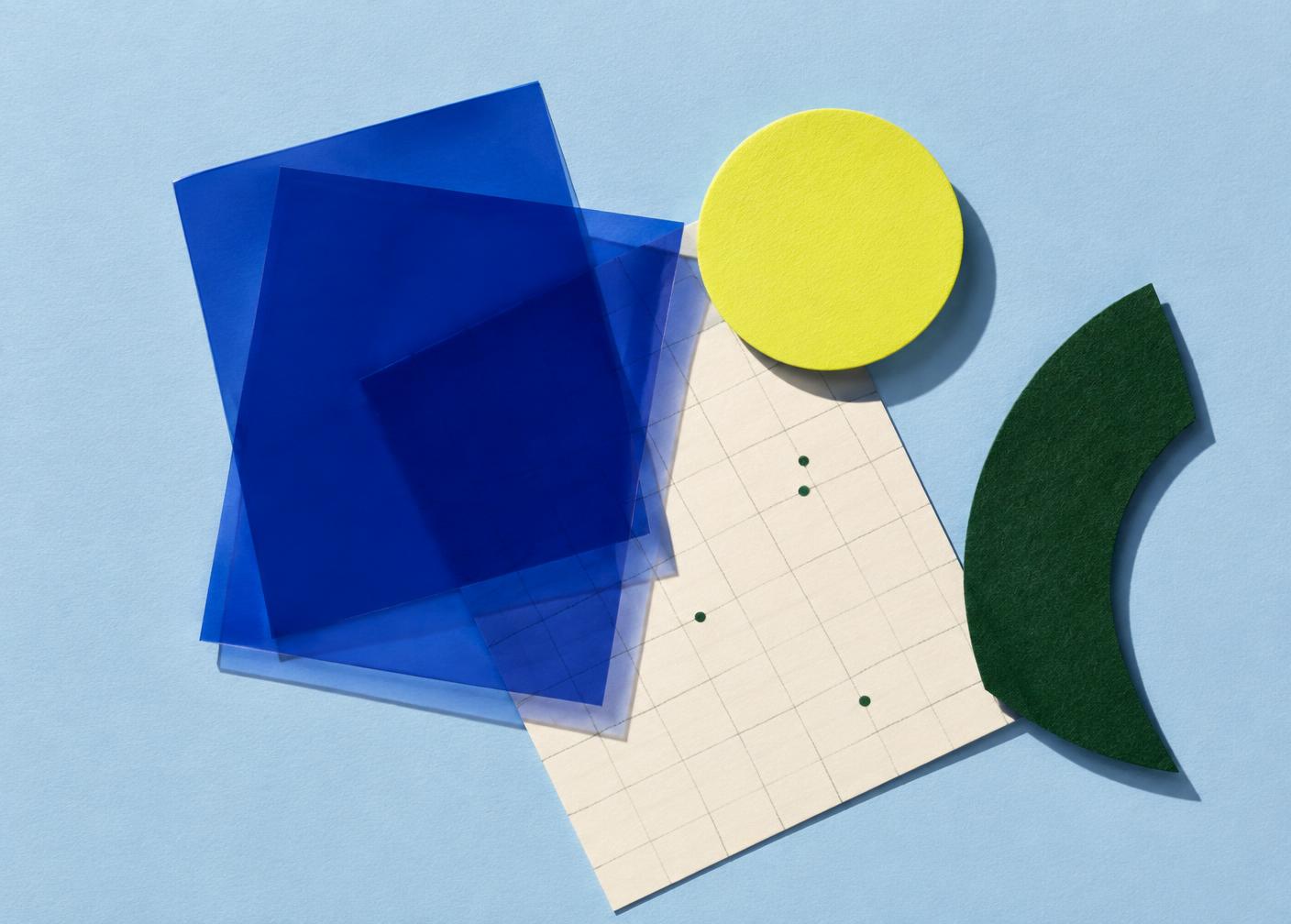 Playful arrangement of blue, green, and yellow design materials